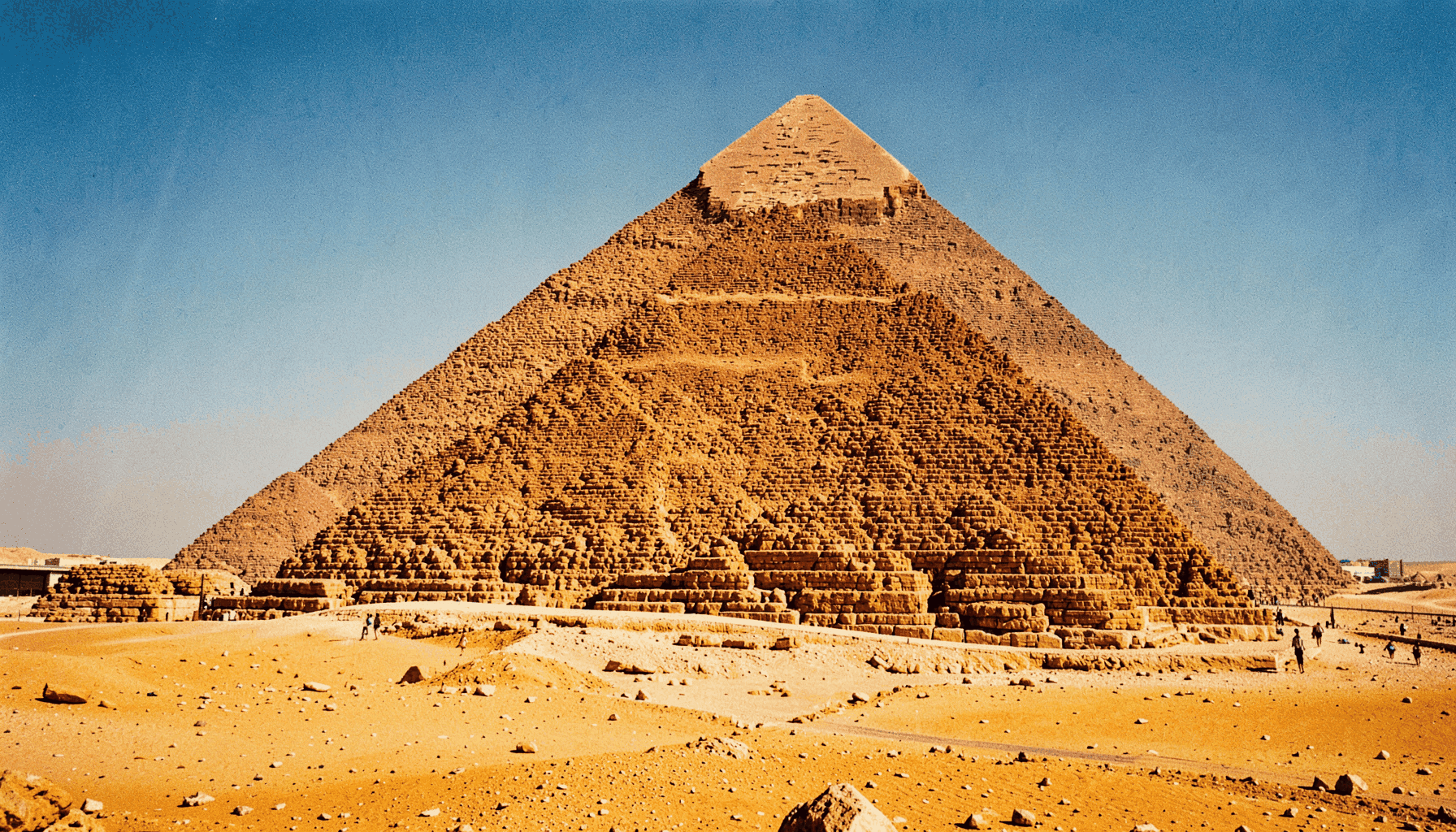 A sunlit view of the Great Pyramids of Giza with golden desert tones and a clear blue sky, conveying the warmth and history of Egypt